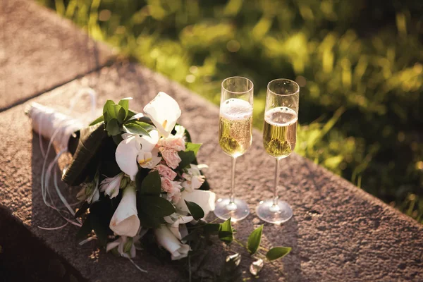 Brautstrauß und zwei Gläser mit Champagner — Stockfoto