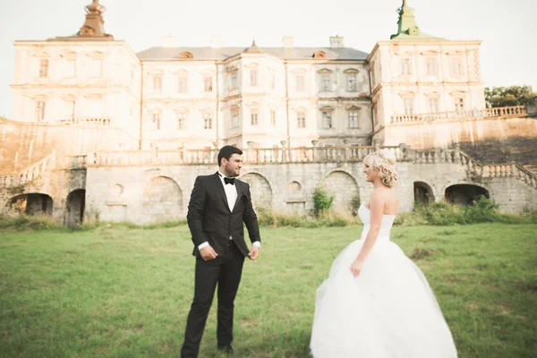 Krásný romantický svatební pár novomanželé objímání v blízkosti starého hradu — Stock fotografie
