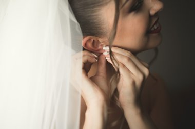 Beyaz elbiseli lüks gelin düğün törenine hazırlanırken poz veriyor.