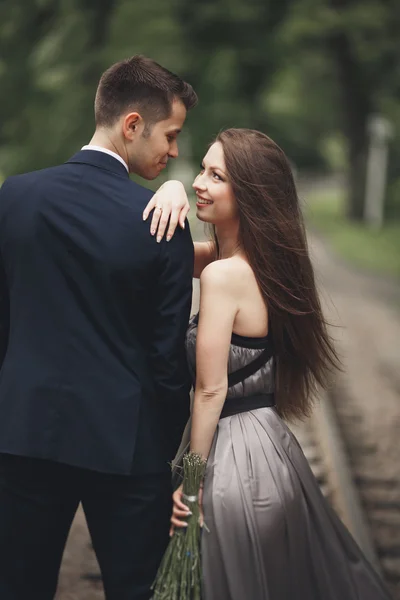Krásný mladý pár, dívka s perfektní šaty pózuje v parku — Stock fotografie