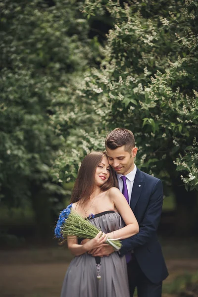 Bonito jovem casal posando ao ar livre após a cerimônia — Fotografia de Stock