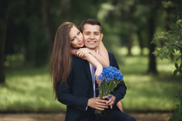 Молодая красивая пара, девушка с идеальным платьем позирует в парке — стоковое фото