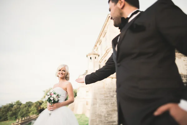 Güzel, romantik bir düğün. Yeni evliler. Eski kalenin yakınlarında sarılıyorlar. — Stok fotoğraf