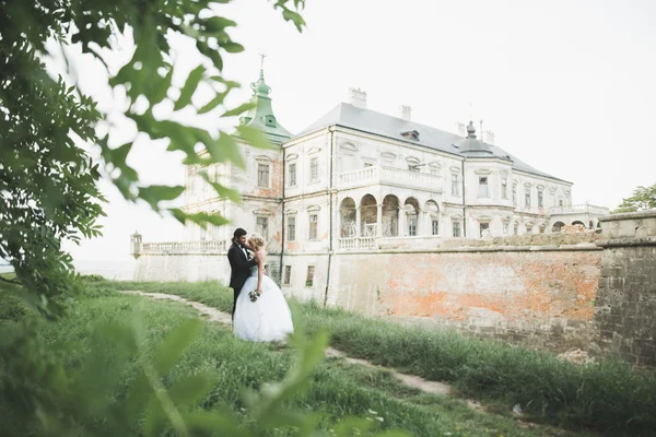 Krásný romantický svatební pár novomanželé objímání v blízkosti starého hradu — Stock fotografie