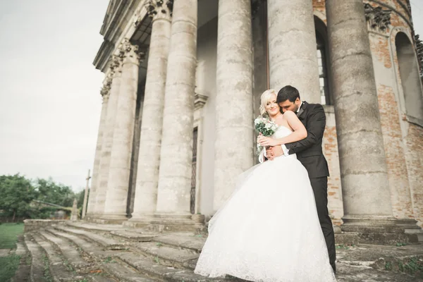 Bella coppia di sposi romantici che si abbracciano vicino al vecchio castello — Foto Stock