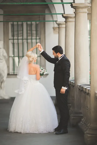 Bella coppia di nozze felice, sposa con abito lungo bianco in posa nella bella città — Foto Stock