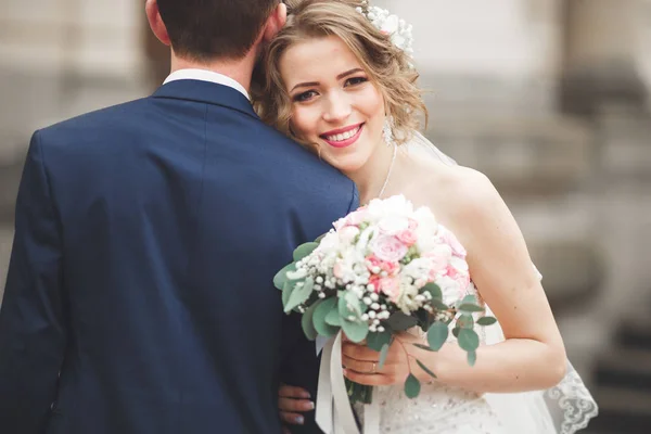 Pareja de recién casados posando y novia sosteniendo en las manos ramo —  Fotos de Stock