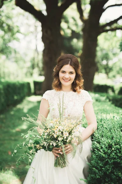 La novia sosteniendo ramo de flores en el parque. Boda — Foto de Stock