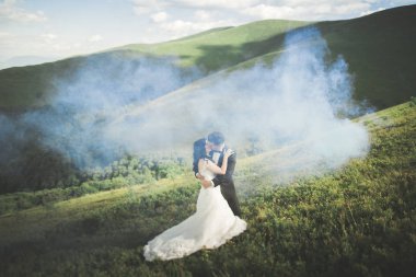 Güzel düğün çift, gelin ve damat, arka planda dağların aşık