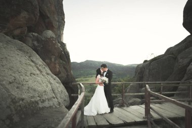 Muhteşem gelin, damat öpüşme ve sarılma Gösterim çarpıcı uçurum yakın: