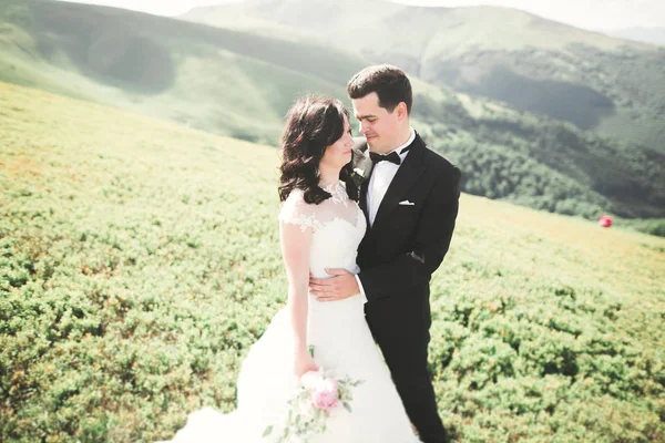Linda noiva linda posando para noivo e se divertindo, cerimônia de luxo em montanhas com vista incrível, espaço para texto, casal de casamento — Fotografia de Stock