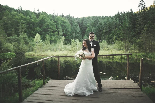 Charmante Braut, eleganter Bräutigam auf Berglandschaften und Sonnenuntergang am See. Prachtvolles Hochzeitspaar — Stockfoto