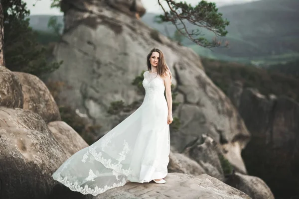 Splendida sposa in abito elegante bouquet in posa vicino alla foresta — Foto Stock