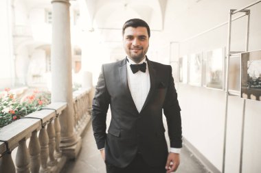 Arka plan eski kale üzerinde poz şık damat