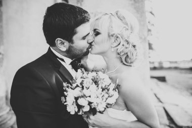 Bahar mevsiminde öpüşen düğün çifti. Yakın plan portre.