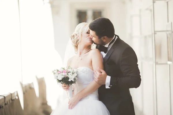 Retrato de feliz pareja de recién casados con ramo de flores — Foto de Stock