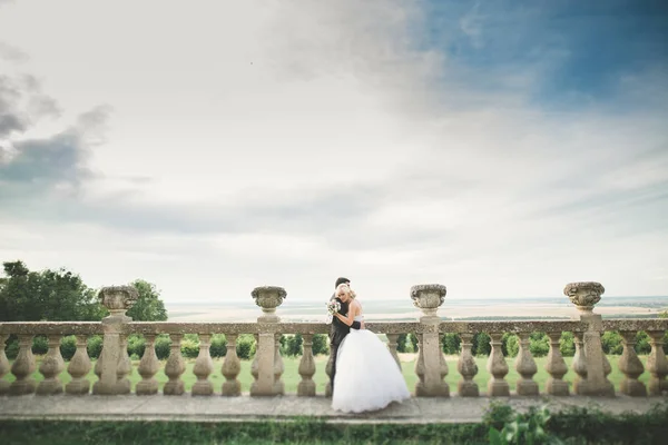 Hermosa boda romántica pareja de recién casados abrazos cerca del viejo castillo —  Fotos de Stock