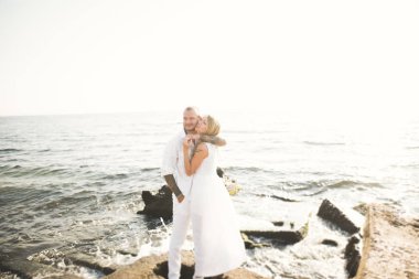 Deniz, mavi gökyüzü yakınındaki taş poz romantik sevgi dolu Çift