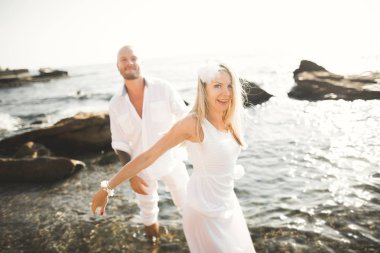 Deniz, mavi gökyüzü yakınındaki taş poz romantik sevgi dolu Çift