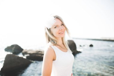 Beyaz elbiseli deniz taşları üzerine poz romantik güzel gelin