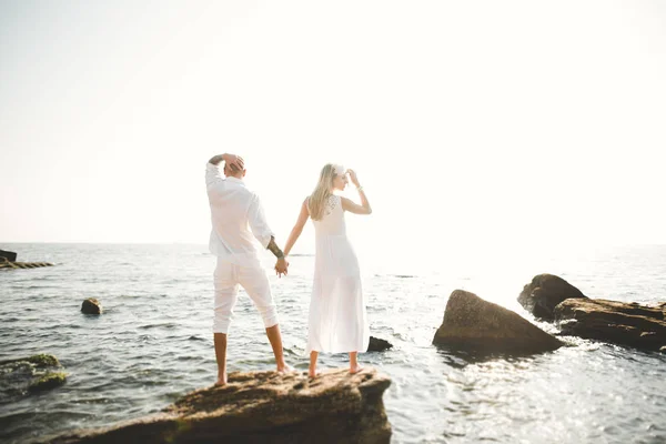 Bara gift bröllop par promenader på stranden vid solnedgången. — Stockfoto