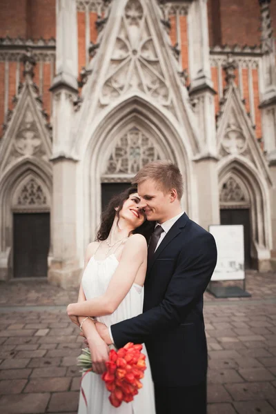 Svatební pár, nevěsta a ženich v blízkosti kostela v Krakově — Stock fotografie