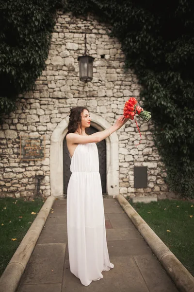 Braut. schöne junge Frau im Park mit Blumenstrauß an einem warmen Sommertag. — Stockfoto