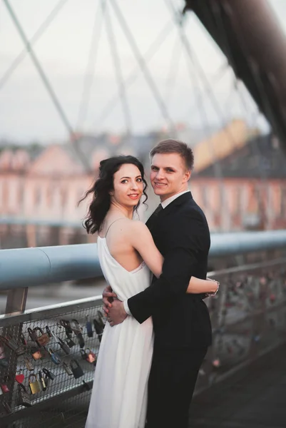 Hochzeitspaar, Braut und Bräutigam posieren auf Brücke in Krakau — Stockfoto