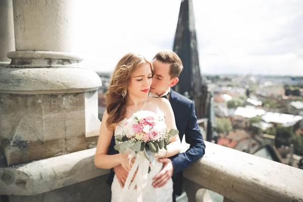 Elegante hermosa pareja de boda besándose y abrazándose en el fondo vista panorámica del casco antiguo — Foto de Stock