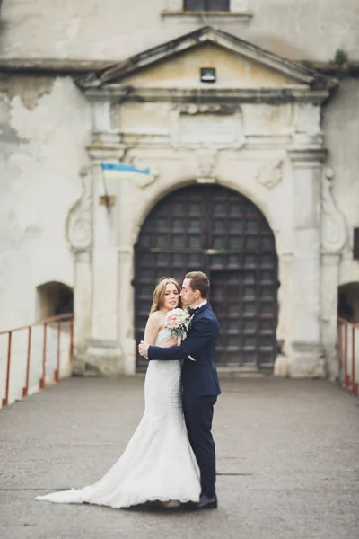 Szczęśliwy wesele para przytulanie i uśmiechając się nawzajem na tle starego zamku — Zdjęcie stockowe