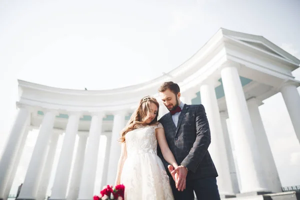 Vackert par, bruden och brudgummen poserar nära stora vita kolumnen — Stockfoto