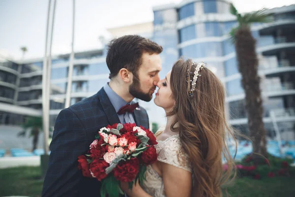 Élégant beau couple posant près du bâtiment en verre moderne — Photo