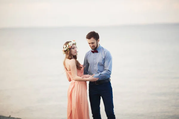 Casamento casal em pé em um cais sobre o mar — Fotografia de Stock