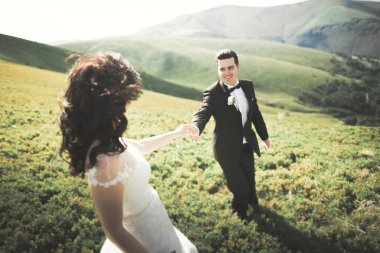 Güzel düğün çift, gelin ve damat, arka planda dağların aşık