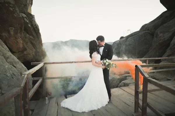 Couple de mariage amoureux embrasser et étreindre près des rochers sur un beau paysage — Photo