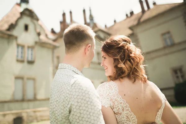 Glückliches Hochzeitspaar umarmt und lächelt sich auf alter Burg an — Stockfoto