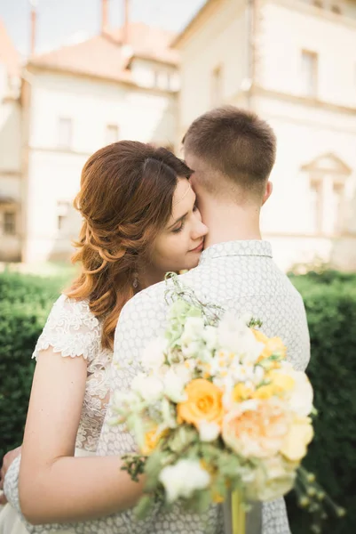 Beautiful fairytale newlywed couple hugging near old medieval castle — Stock Photo, Image