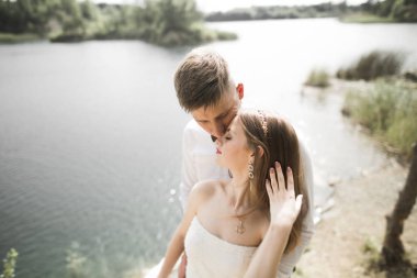 Öpüşen düğün çifti güzel manzarada kalıyor.