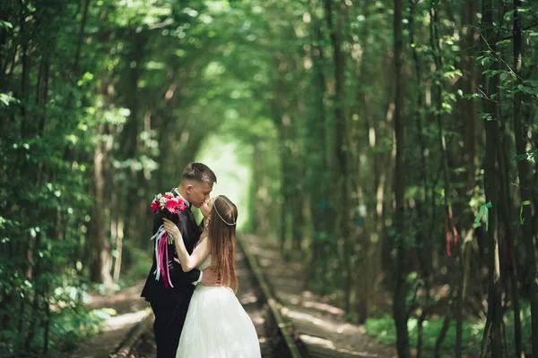 Счастливая супружеская пара очаровательный жених и идеальная невеста позирует в парке — стоковое фото