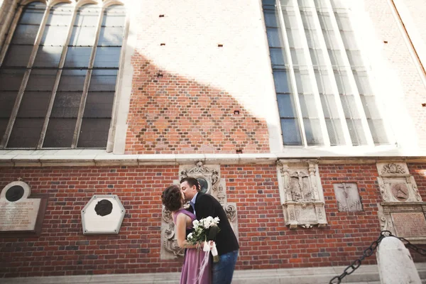 Splendida coppia di nozze, sposo e sposa con abito rosa passeggiando nella città vecchia di Cracovia — Foto Stock