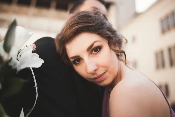 Šťastný, Svatební pár, ženich, nevěsta s růžové šaty objímání a usmívá se vzájemně na pozadí stěny v zámku — Stock fotografie