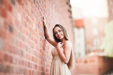 Uzun saç ve elbise mükemmel şekli tabaklanmış vücut possing duvarının yakınında güzel seksi kız