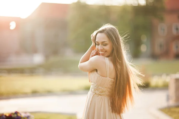 Vonzó fiatal nő élvez ideje kívül park sunset háttérben hosszú ruha — Stock Fotó