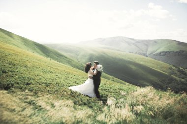 Güzel düğün çift, gelin ve damat, arka planda dağların aşık