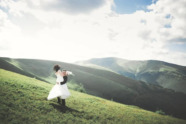 Vackra bröllopsparet, bruden och brudgummen, i kärlek på bakgrund av berg — Stockfoto