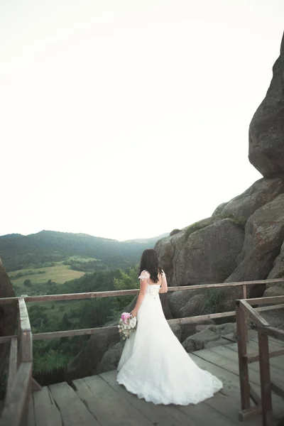Schöne Braut posiert in der Nähe von Felsen mit perfekter Aussicht — Stockfoto