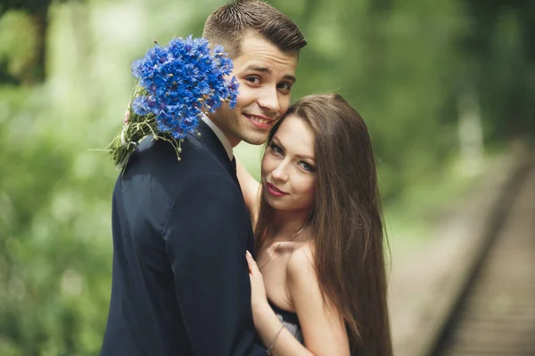 Unga vackra par, tjej med perfekta klänningen poserar i park — Stockfoto