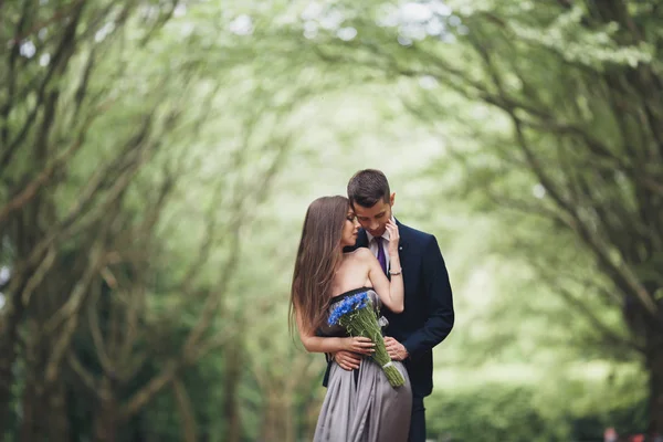 Knappe jonge paar poseren buitenshuis na de ceremonie — Stockfoto