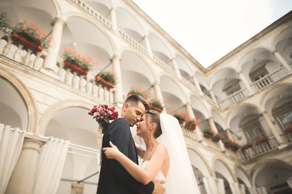Bella coppia di nozze felice, sposa con abito lungo bianco in posa nella bella città — Foto Stock