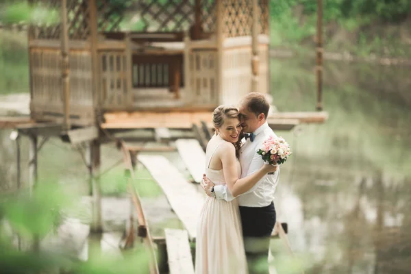 Жених целует невесту в лоб, когда она наклоняется к нему улыбаясь — стоковое фото